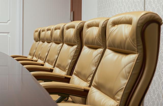 Boardroom corporate governance meeting with directors reviewing agendas